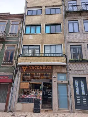 a large brick building with a vazaordinaryarma sign in front at Bolhão Apartment in Porto