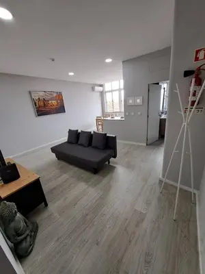 a living room with a black couch and a table at Bolhão Apartment in Porto