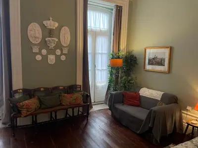 a living room with a couch and a window at Estúdio Histórico século XIX com Varanda e Vistas para a Baixa in Porto