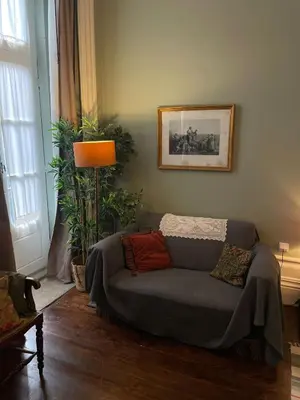 a living room with a couch and a lamp at Estúdio Histórico século XIX com Varanda e Vistas para a Baixa in Porto