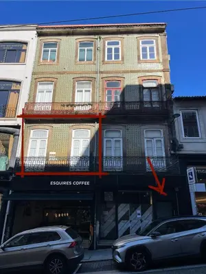 a building with cars parked in front of it at Estúdio Histórico século XIX com Varanda e Vistas para a Baixa in Porto