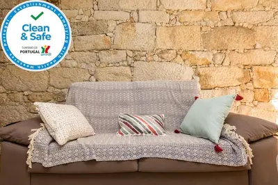 a couch with pillows on it in front of a brick wall at Trendy Porto in Porto