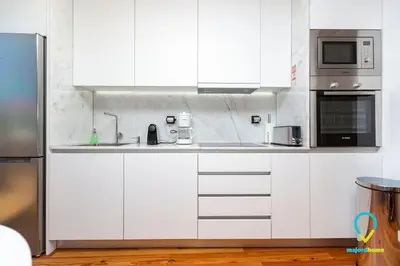 a white kitchen with a sink and a microwave at So Trendy Porto in Porto