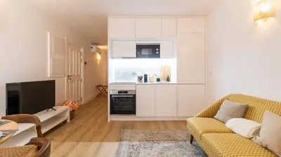 a living room with a couch and a kitchen at Urban House Marquês by LovelyStay in Porto