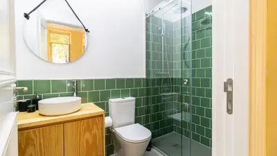 a bathroom with a toilet and a sink and a mirror at Urban House Marquês by LovelyStay in Porto