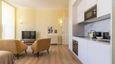 a kitchen with a counter and two chairs in a room at Urban House Marquês by LovelyStay in Porto