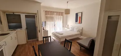 a kitchen and a living room with a couch and a table at Constituição 1012 in Porto