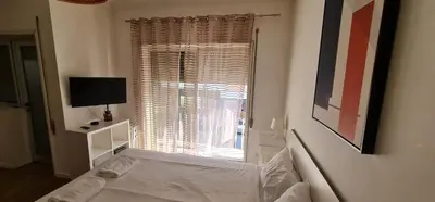 a white bedroom with a bed and a window at Constituição 1012 in Porto