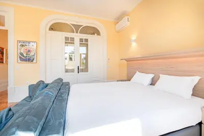 a bedroom with two beds and a couch in it at Downtown Grand Houses in Porto