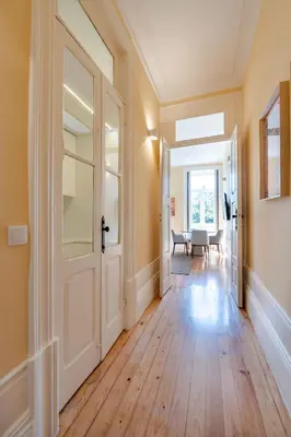 an empty hallway with a white door and wooden floors at Downtown Grand Houses in Porto