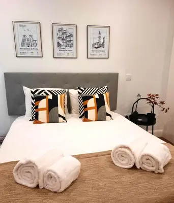 a bedroom with a white bed with towels on it at Smiling Places - Apartment in Porto in Porto