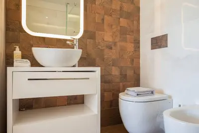 a bathroom with a sink and a toilet and a mirror at Comfy Porto in Porto