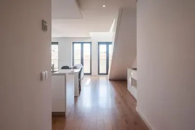 a white room with a kitchen and a dining table at Comfy Porto in Porto