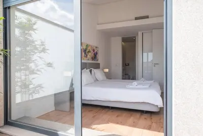 a bedroom with a bed and a large glass window at Comfy Porto in Porto