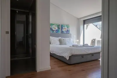 a bedroom with a large bed and a glass window at Comfy Porto in Porto