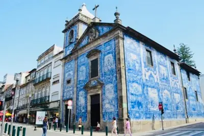 a blue building with people walking in front of it at Apartment Boutique Santa Catarina 1 in Porto
