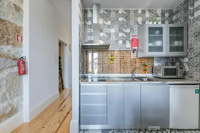 a kitchen with a sink and a microwave at GuestReady - Comendador Sto Ildefonso in Porto
