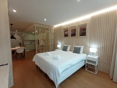a bedroom with a large white bed and a desk at 714 Galé Apartment Wi-Fi in Porto