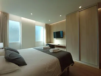 a bedroom with a large bed and a television at 714 Galé Apartment Wi-Fi in Porto