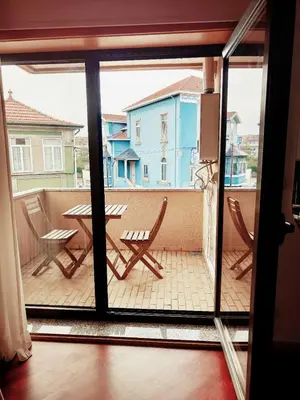 a bedroom with a bed and a chair and a window at Home Essences in Porto