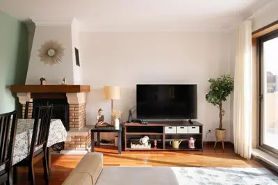 a living room with a large window and a television at Home Essences in Porto