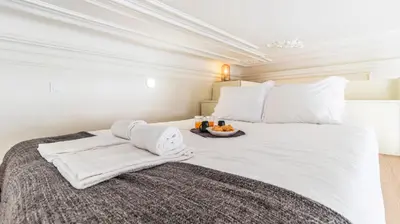 a white bed with a bowl of fruit on it at Boavista Loft by LovelyStay in Porto