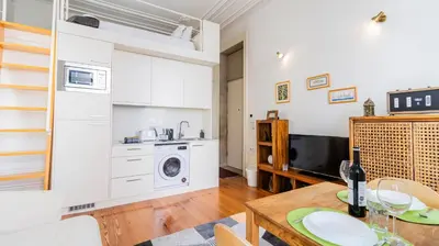 a kitchen and living room with a table and a microwave at Boavista Loft by LovelyStay in Porto
