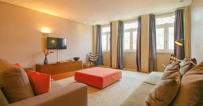 a living room with a couch and a red stool at ALIADOS by YoursPorto in Porto