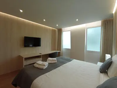 a hotel room with a bed with towels on it at 715 Galé Apartment Wi-Fi, Estacionamento in Porto