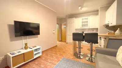 a living room with two chairs and a flat screen tv at RIBEIRA by YoursPorto in Porto