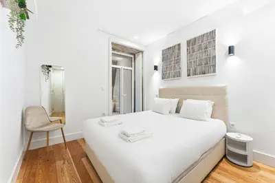 a white bedroom with a white bed and a chair at Porto Calm Terrace Apartment in Porto