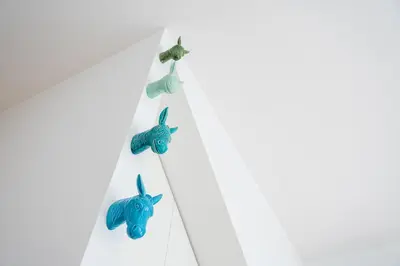 three blue fish hooks hanging on a white wall at Porto Calm Terrace Apartment in Porto