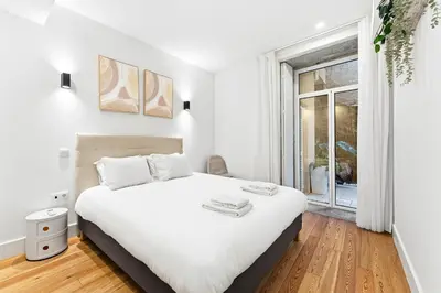a bedroom with a large white bed and a window at Porto Calm Terrace Apartment in Porto