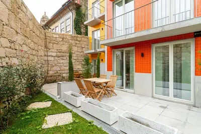 a patio with a table and chairs in front of a building at GuestReady - Cozy Vitoria Apartment in Porto