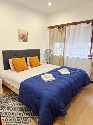 a bedroom with a large bed with towels on it at Downtown 2 minutes by walk to center and metro-direct to airpot T4 in Porto
