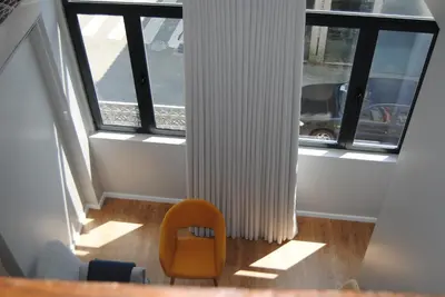 a orange chair in a room with windows at Gaia Loves You - Jardim do Morro in Vila Nova de Gaia
