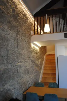 a meeting room with a stone wall and a staircase at Gaia Loves You - Ponte D. Luis in Vila Nova de Gaia