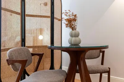 a table with two chairs and a vase on it at Ando Living - Flores 200 House in Porto