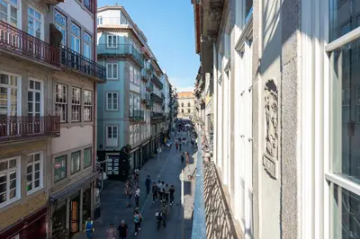 a group of people walking down a street between buildings at Ando Living - Flores 200 House in Porto
