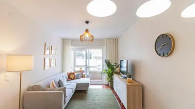 a living room with a couch and a clock on the wall at Urban Retreat Porto by LovelyStay in Porto