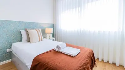 a bedroom with a bed with white sheets and a window at Urban Retreat Porto by LovelyStay in Porto