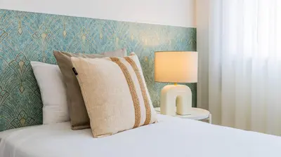 a white bed with a pillow and a lamp at Urban Retreat Porto by LovelyStay in Porto