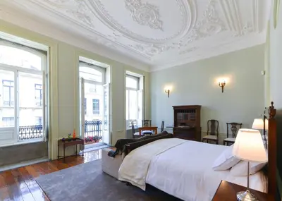 a bedroom with a large bed with a white ceiling at Maison des Amis Porto in Porto