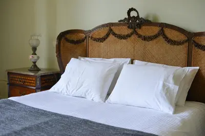a bed with white pillows and a wooden headboard at Maison des Amis Porto in Porto