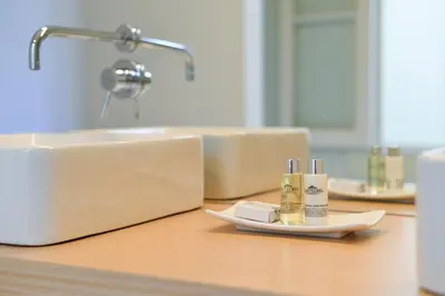 a bathroom counter with a sink and two bottles of soap at Maison des Amis Porto in Porto