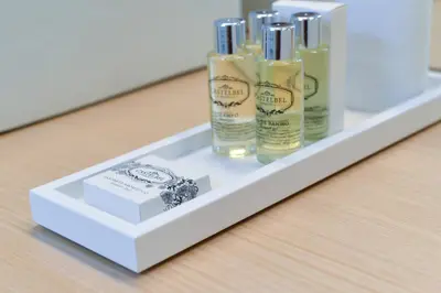 a shelf with three bottles of hair products on it at Maison des Amis Porto in Porto