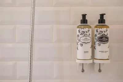 two bottles of soap on a shelf in a bathroom at Nautical Luxury Loft in Porto
