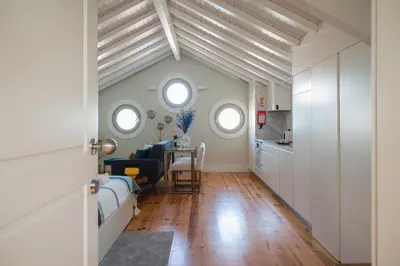 a room with white walls and wooden floors and windows at Nautical Luxury Loft in Porto