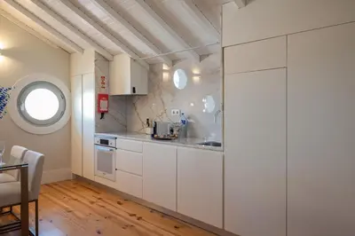 a kitchen with white cabinets and a window at Nautical Luxury Loft in Porto