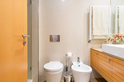 a bathroom with a white toilet and a sink at GuestReady - Freixo lux with Douro River view in Porto